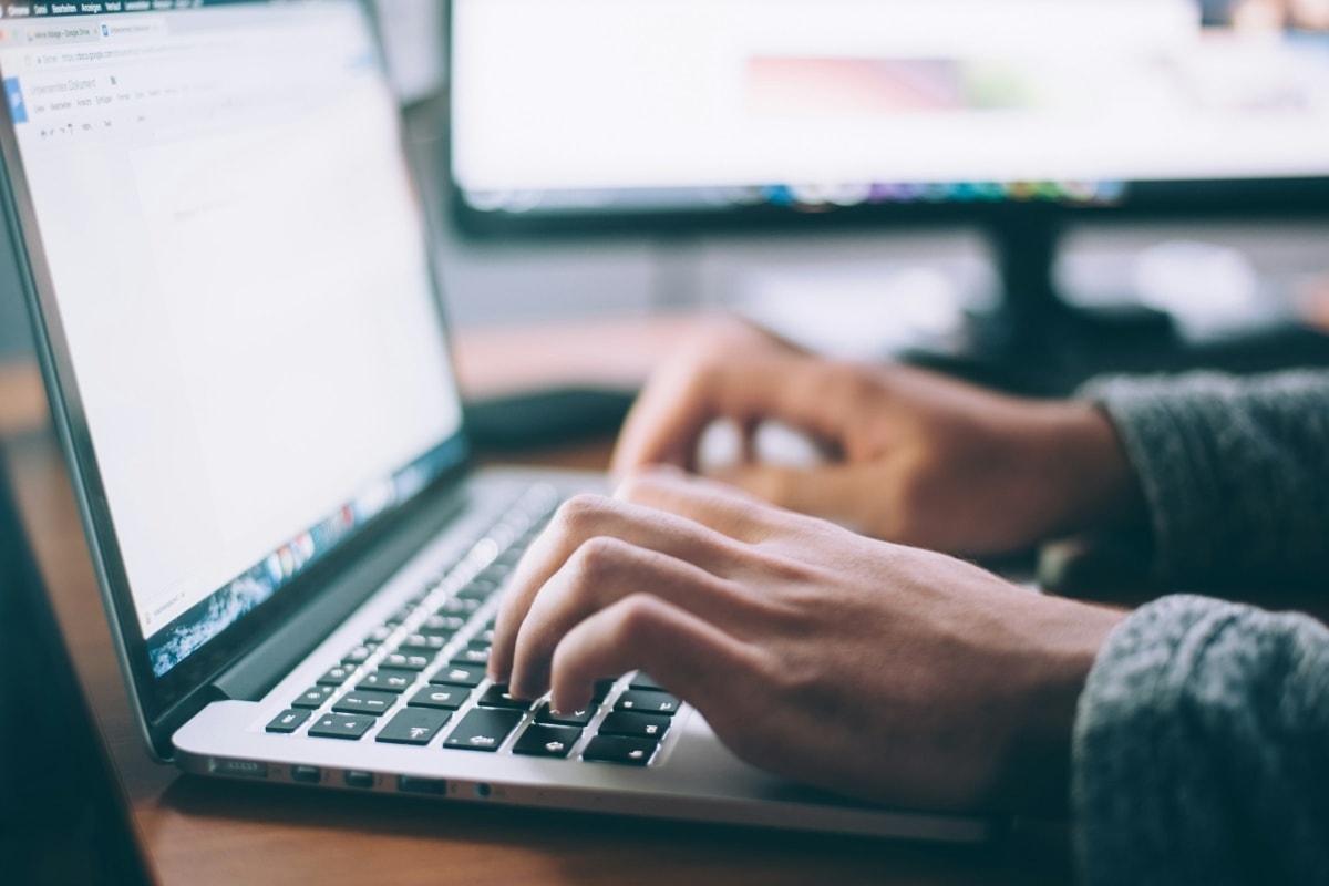 close-up of gentleman typing on computer 