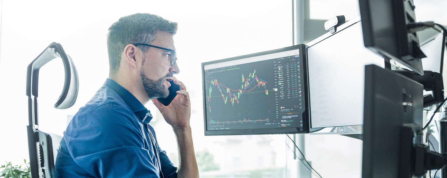 business advisor looking at multiple computer screens