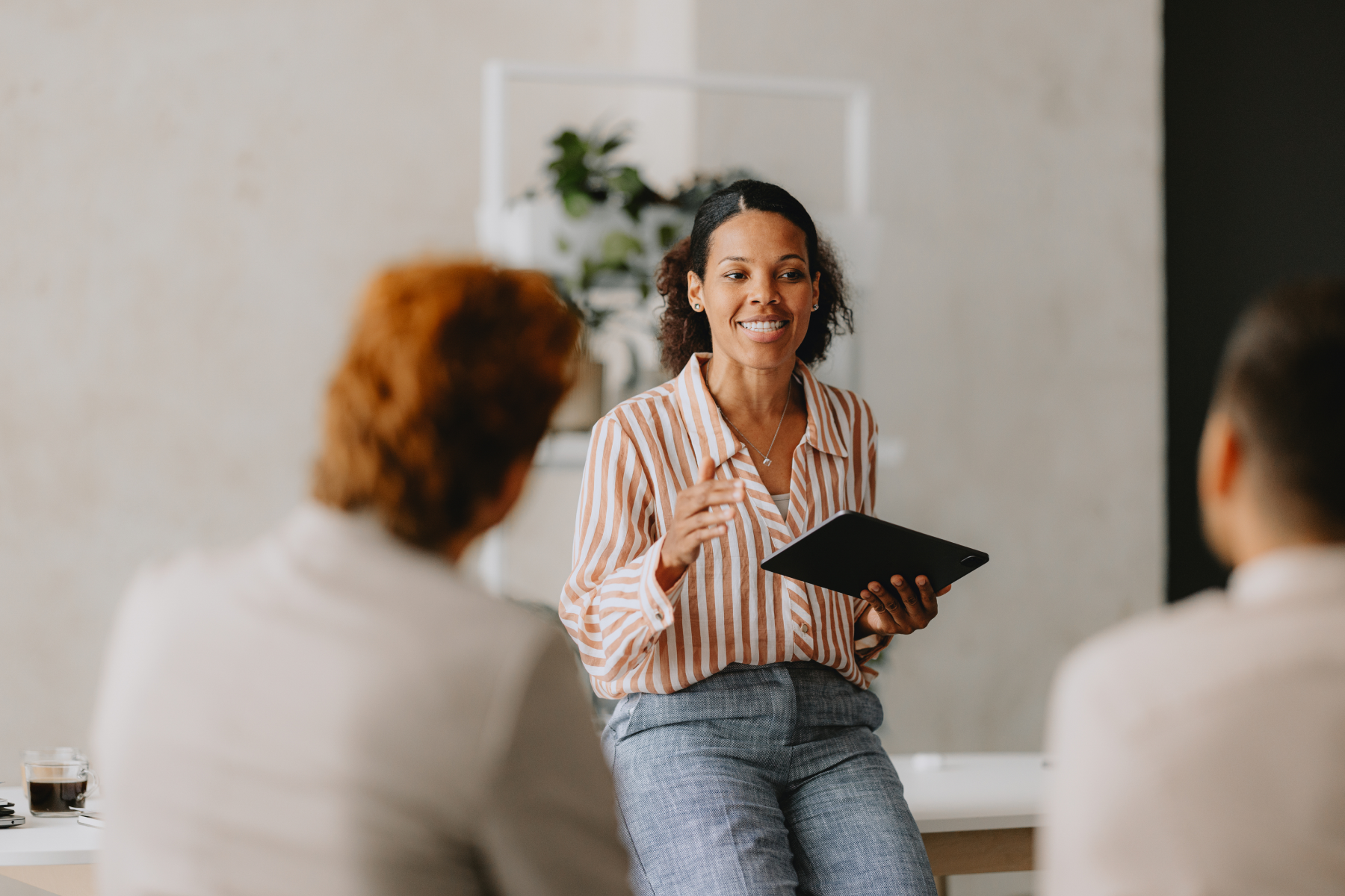 financial advisor leading a team discussion with a tablet during a strategy session